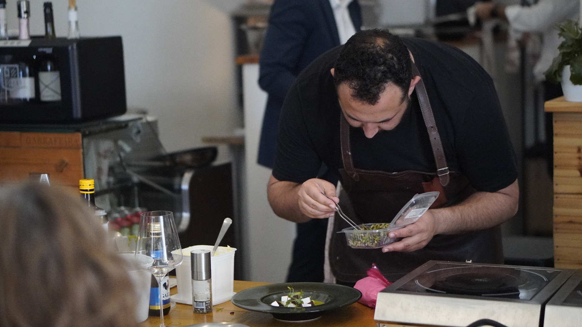 Chef preparing a curated meal at a local partner restaurant